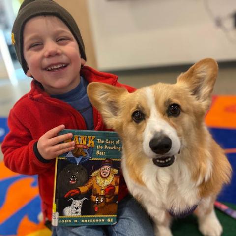 image of child with book and dog