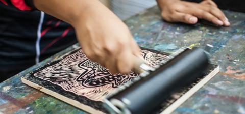 image of hands rolling paint on a block print