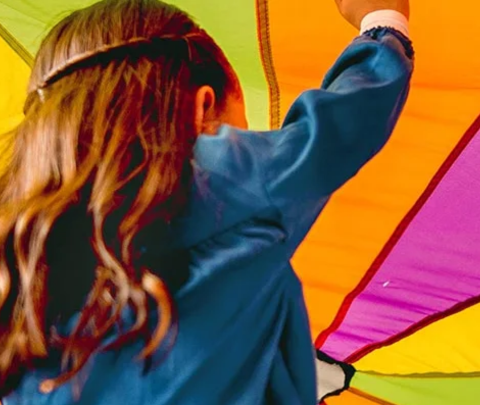 image of child under a parachute