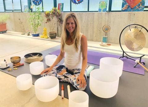 Photo of Kari Potter surrounded by sound bowls