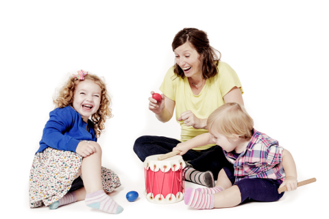 image of a mother and two small children laughing and playing instruments