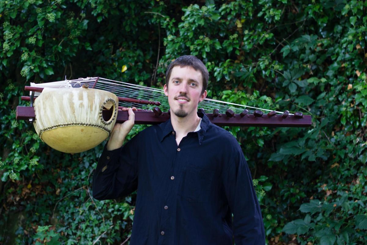 image of the musician holding the kora over his shoulder