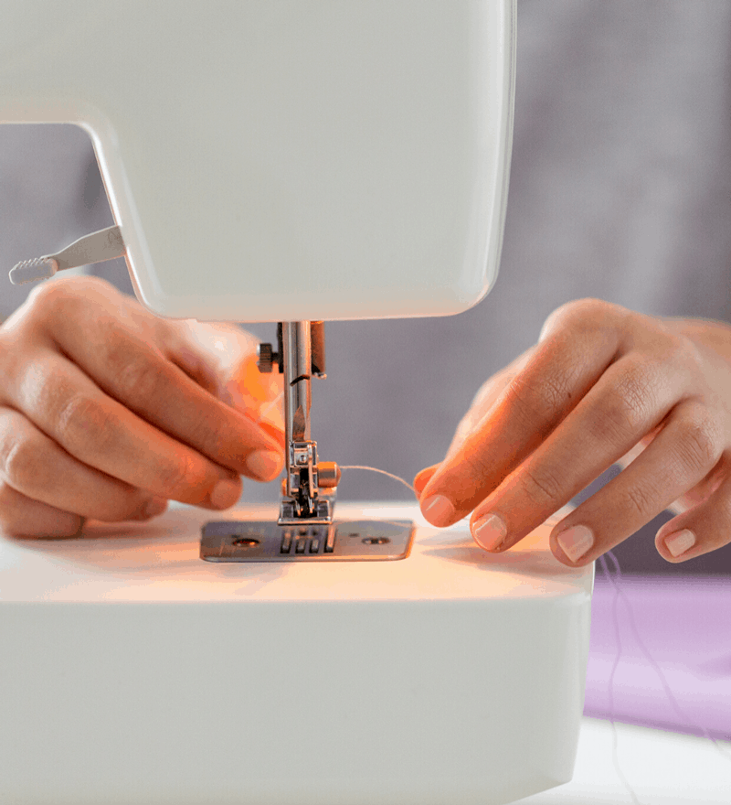 image of hands operating a sewing machine