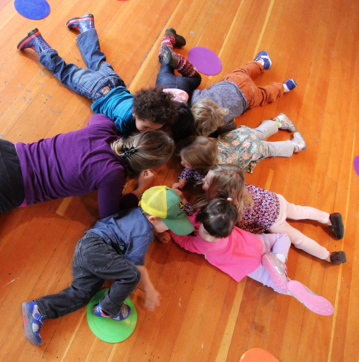 Children laying on the ground making a circle.